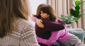 A supportive hug between two women, illustrating Outcomes Lab's compassionate NDIS Positive Behaviour Support services